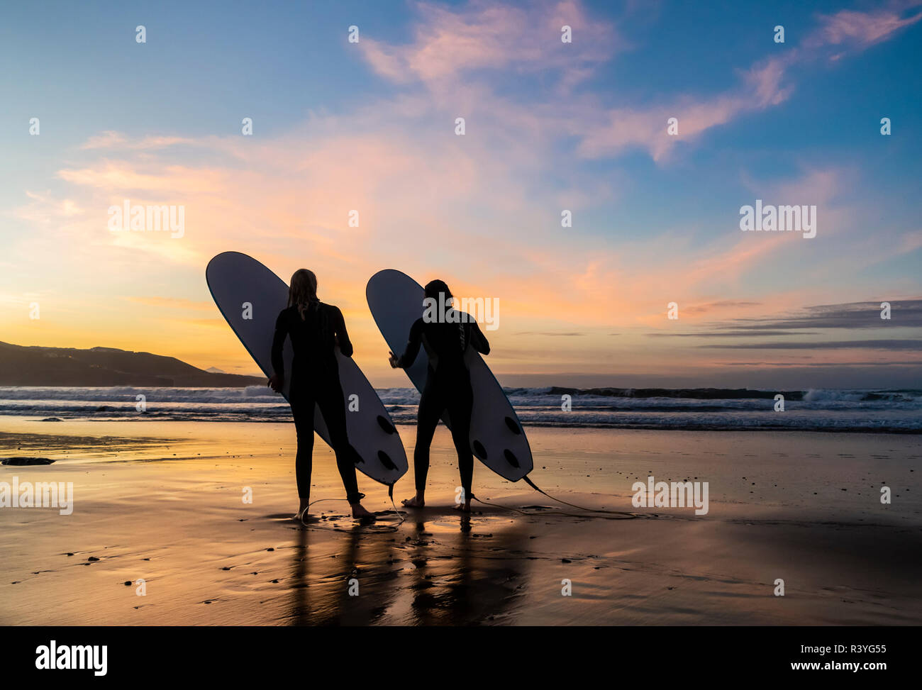 Surfer bei Sonnenuntergang. Stockfoto