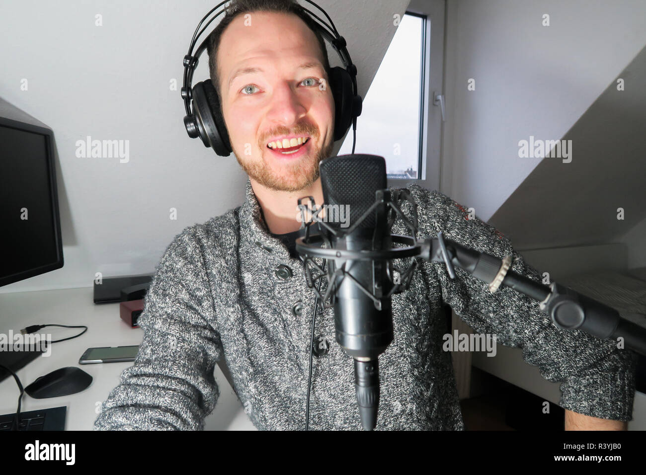 Junge männliche hinter Kondensator Mikrofon radio podcast Host voice recording Stockfoto