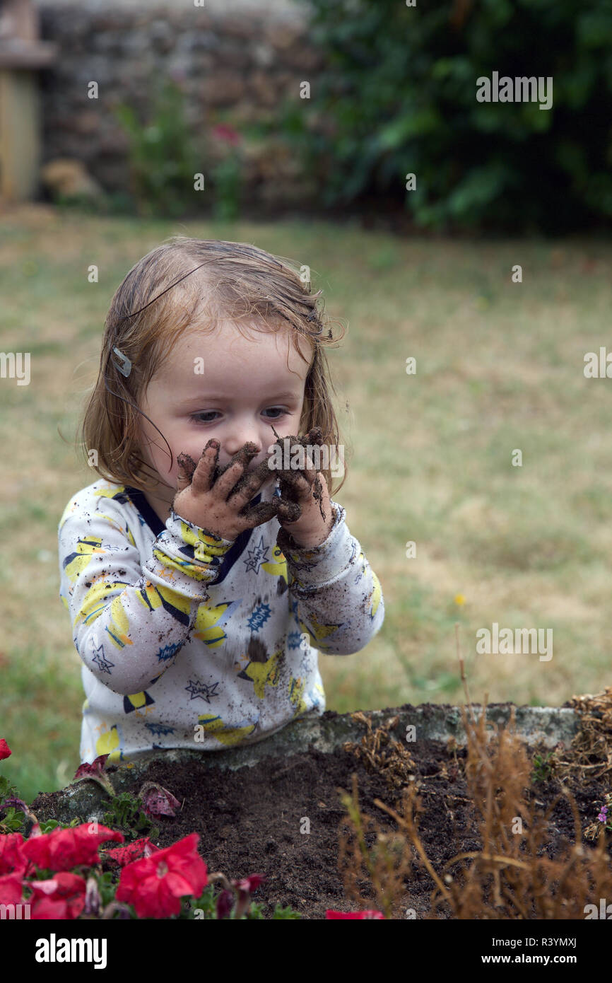 Kleinkind spielen in den Schmutz im Garten Stockfoto