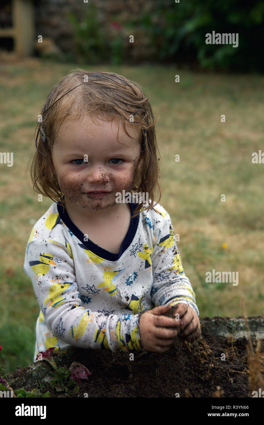 Kleinkind spielen in den Schmutz im Garten Stockfoto