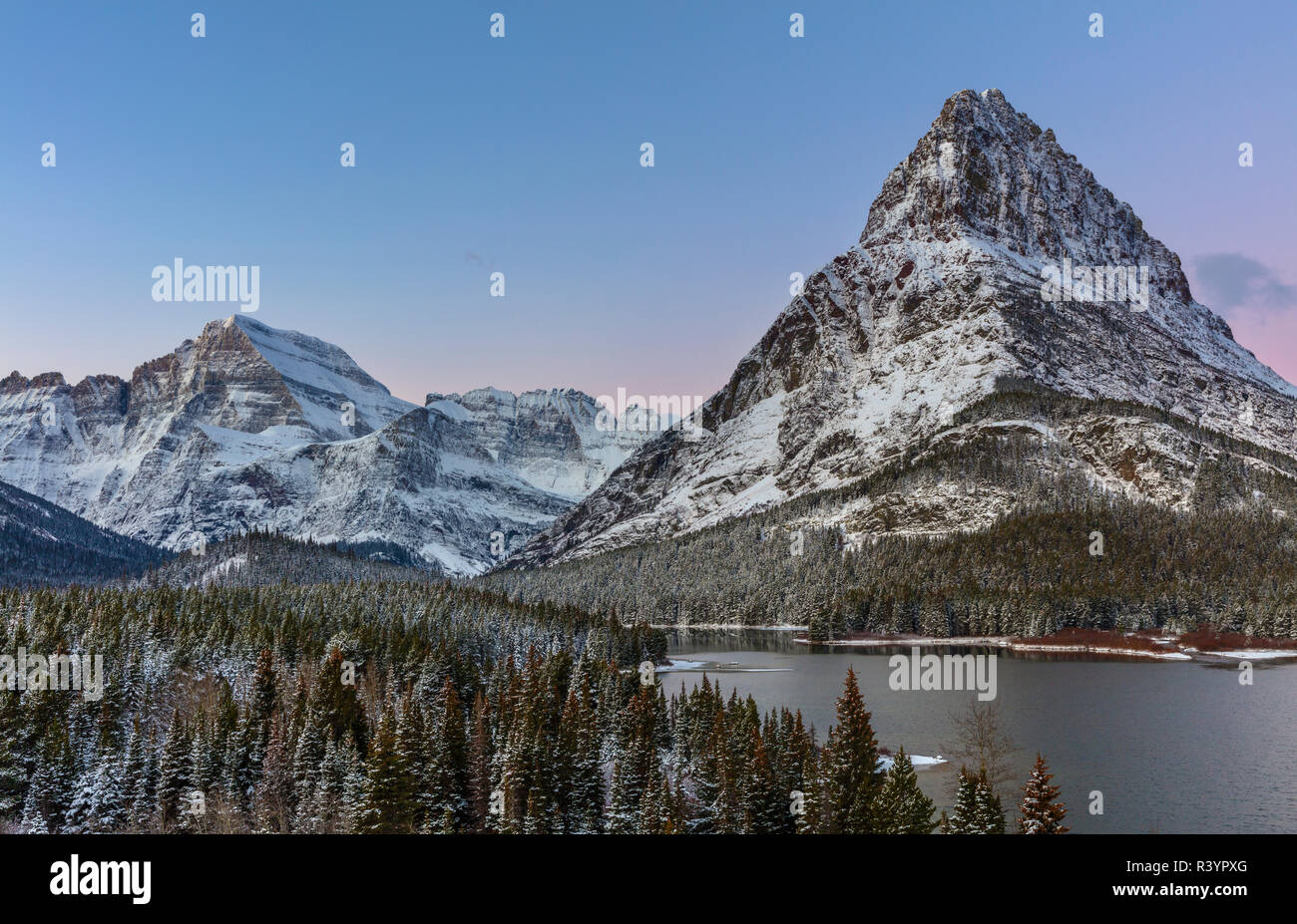 Grinnell Point und Mount Gould über Swift Current See im frühen Winter im Glacier National Park, Montana, USA Stockfoto