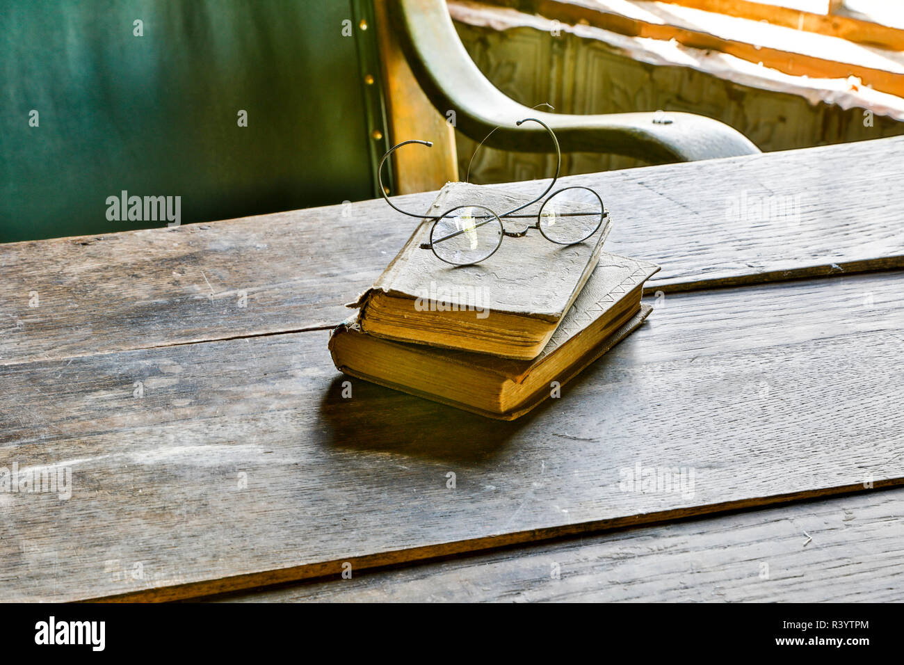 USA, Montana. Nevada City, ein lebendiges Museum, antike Bücher und Gläser auf dem Tisch Stockfoto