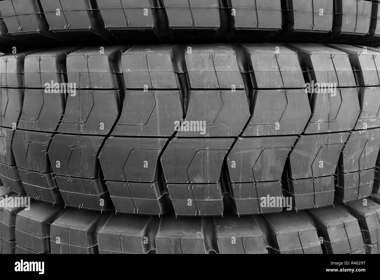 Stapel von riesigen industriellen Größe neue schwarze Gummireifen mit Muster treten. Stockfoto