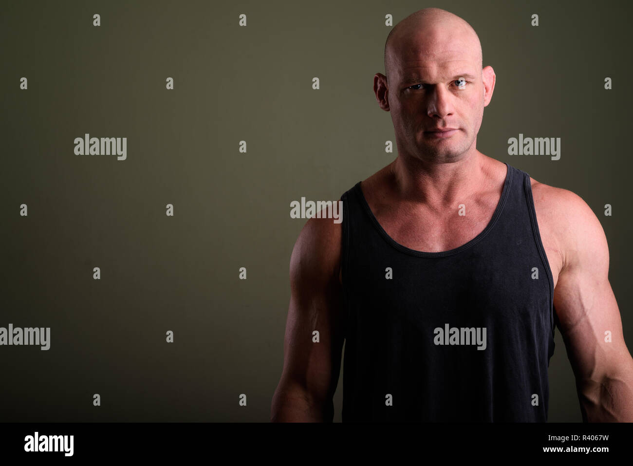 Kahlen muskulösen Mann mit Tank Top gegen farbigen Hintergrund Stockfoto