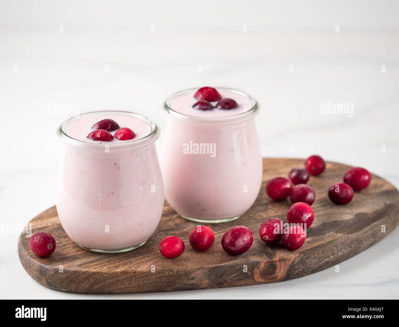 Joghurt mit Cranberry. Zwei Glas Glas mit rosa Joghurt oder Milchshake ...
