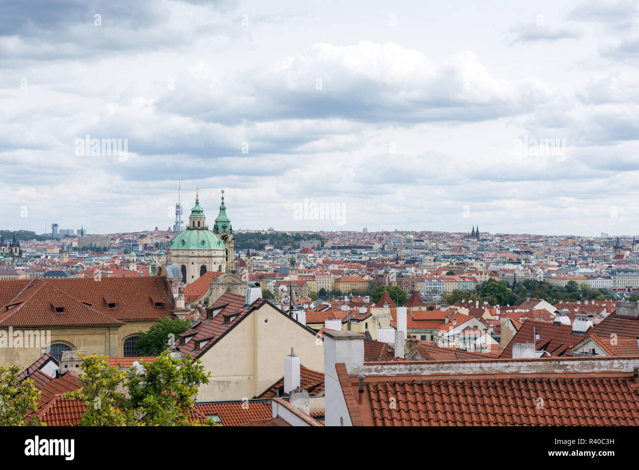 Prag Panorama mit bunten Dächern an einem bewölkten Tag, mit der Kirche St. Nikolaus und Zizkov Fernsehturm in der Ferne Stockfoto