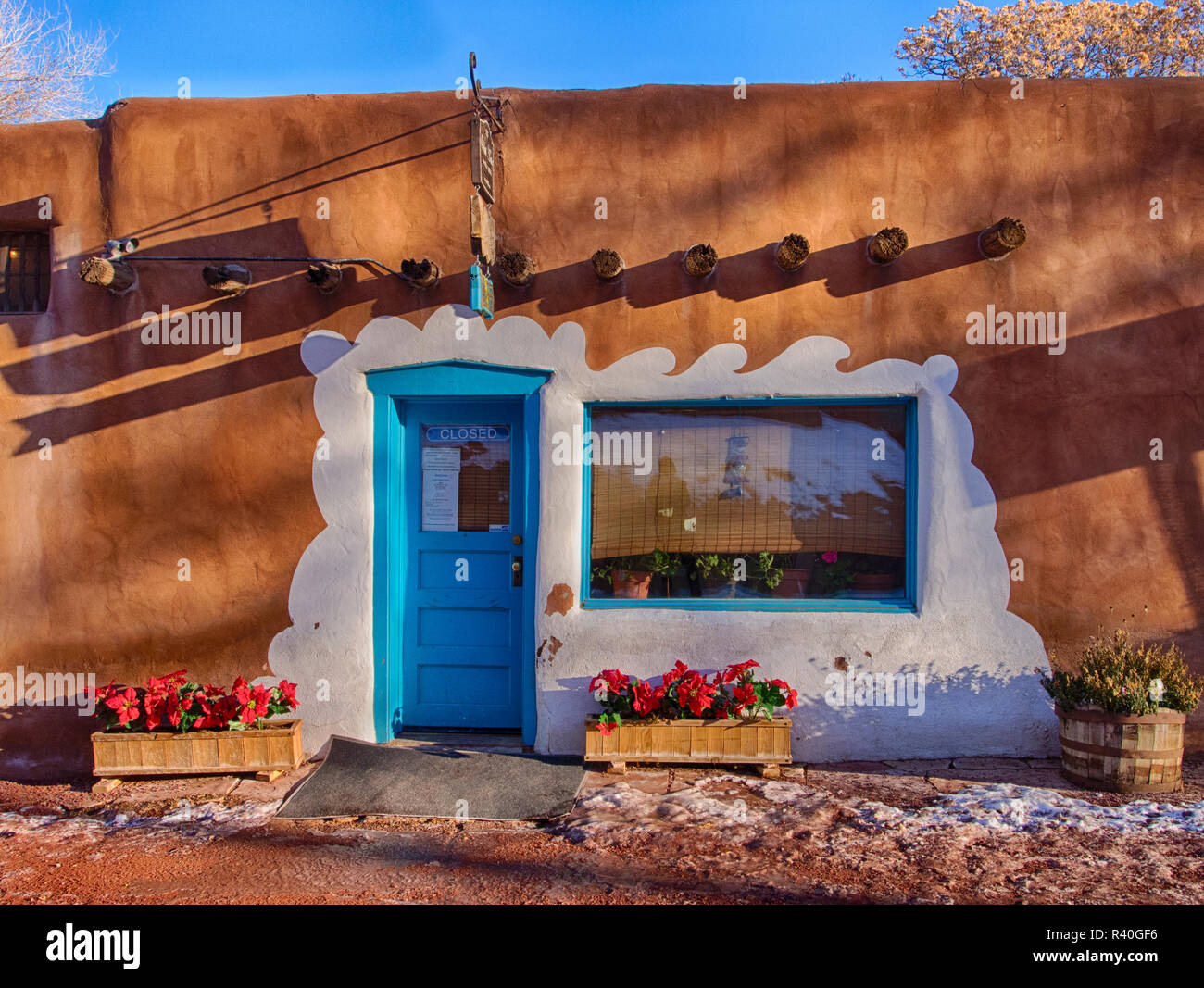 USA, New Mexiko, Sant Fe, Adobe Struktur mit überstehenden vigas und blaue Tür Stockfoto