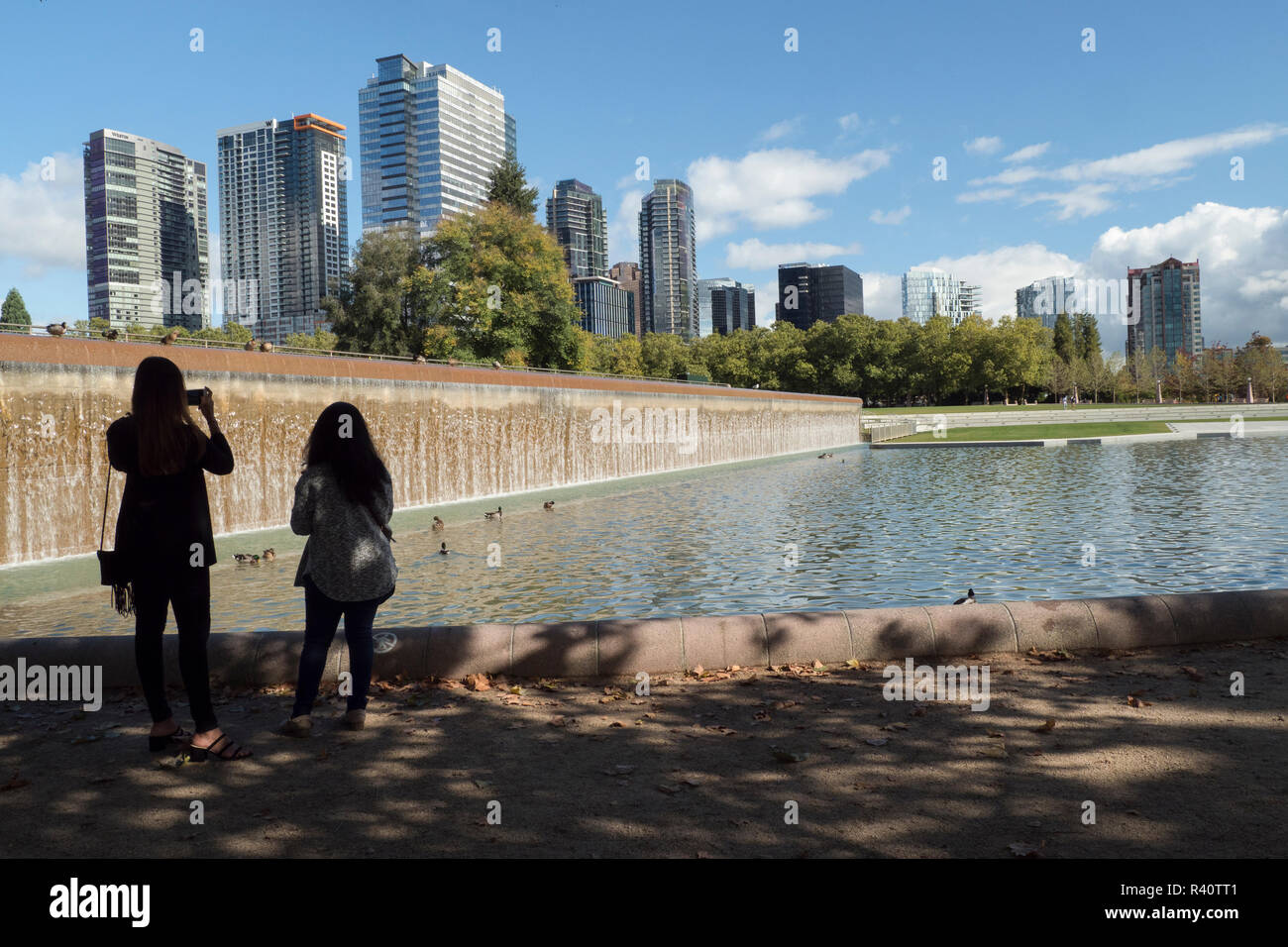 USA, Washington State, Bellevue. Teich und Wasserfall im Downtown Park, mit Skyline. (Redaktionelle nur verwenden) Stockfoto
