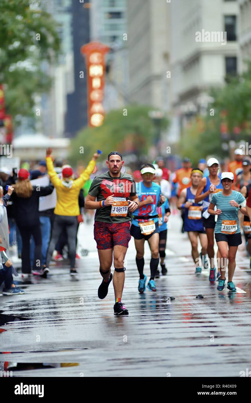 Chicago, Illinois, USA. Läufer und die Farbe fließt auf der State Street ungefähr zwei Meilen in die Chicago Marathon 2018. Stockfoto