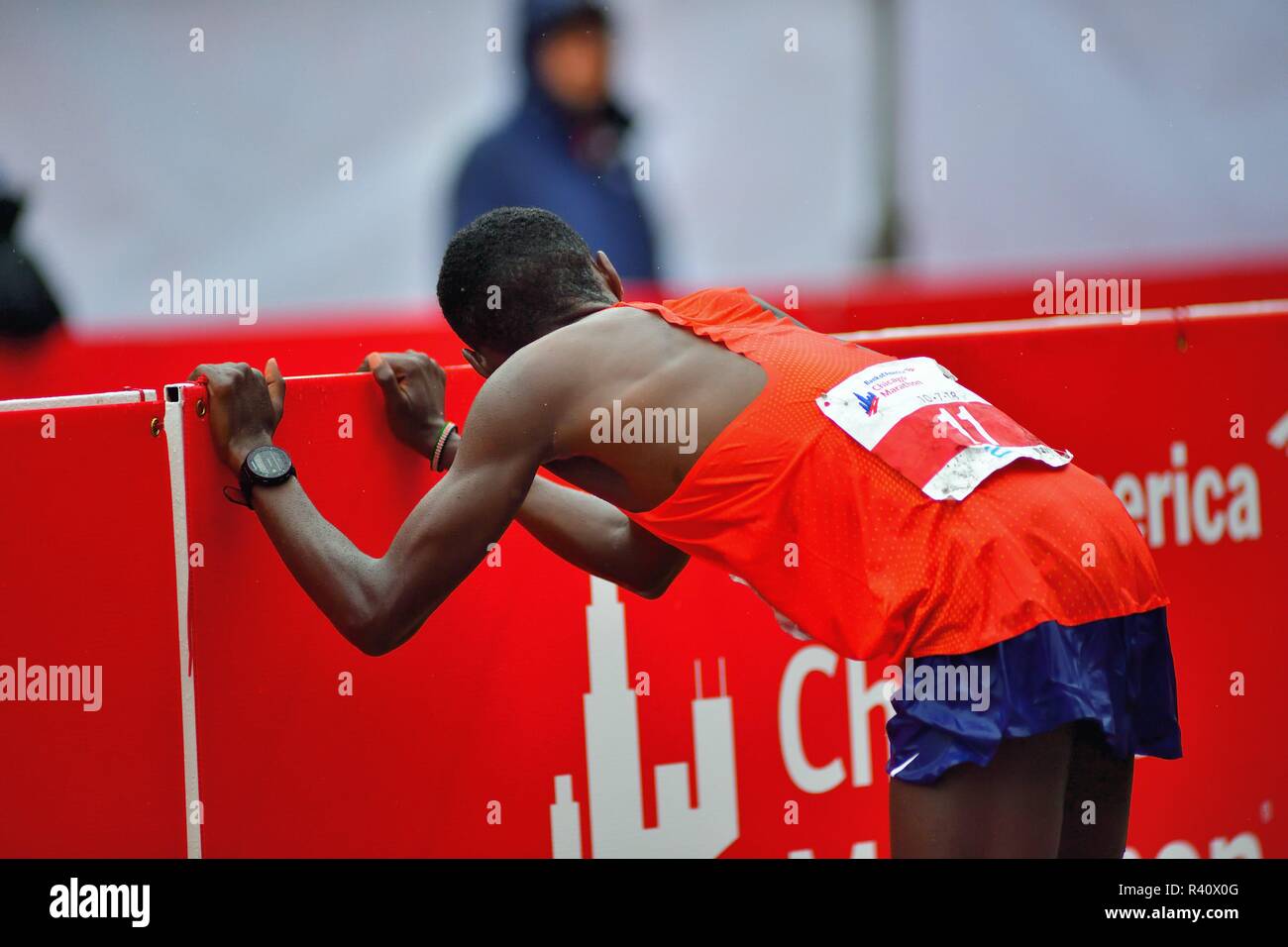 Chicago, Illinois, USA. Bedan Karoki von Kenia ermüdet und erschöpft nach dem Überqueren der Ziellinie am Chicago Marathon 2018. Karoki, läuft in o Stockfoto