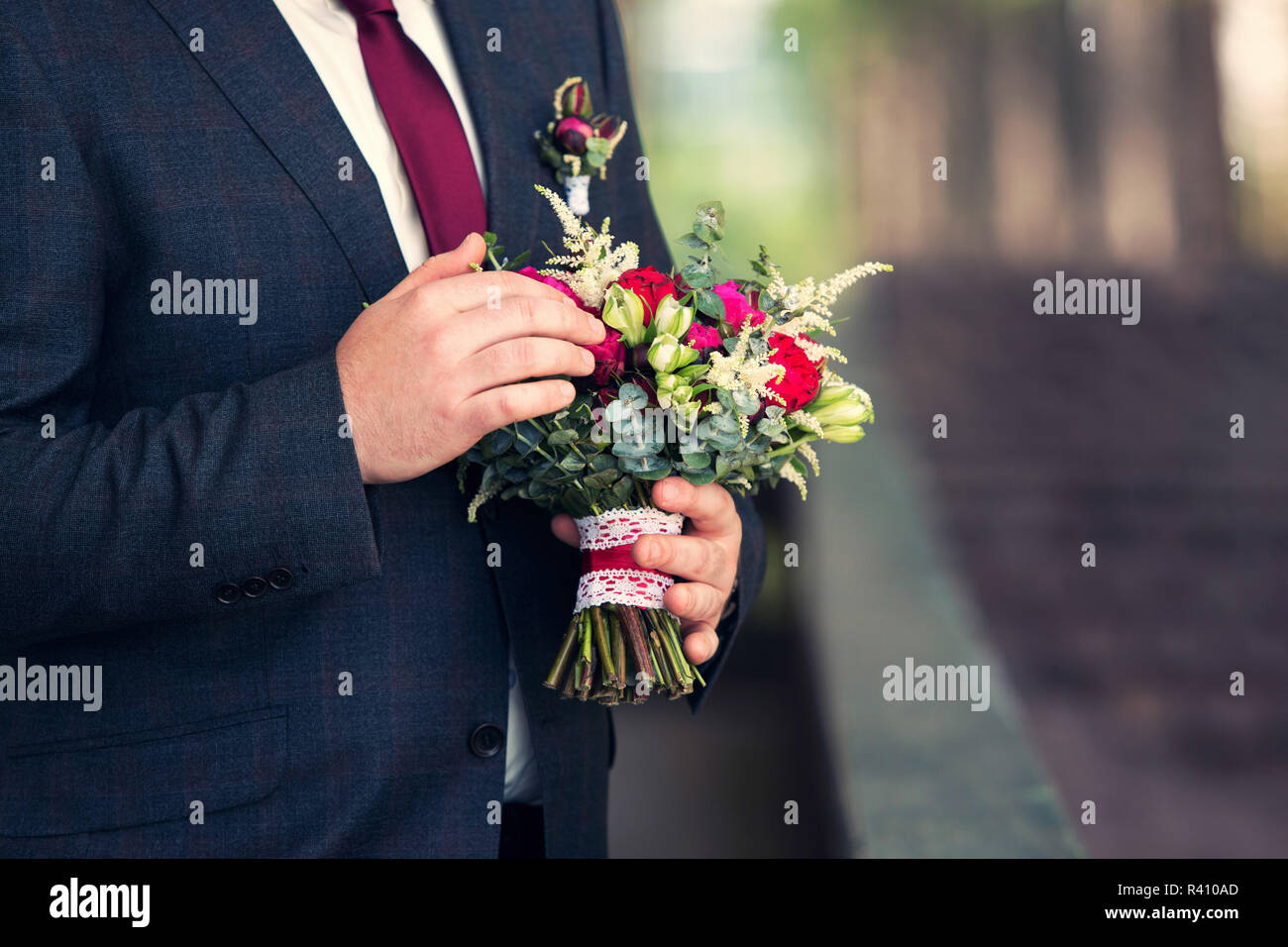 Brautstrauß in Händen des Bräutigams Stockfoto