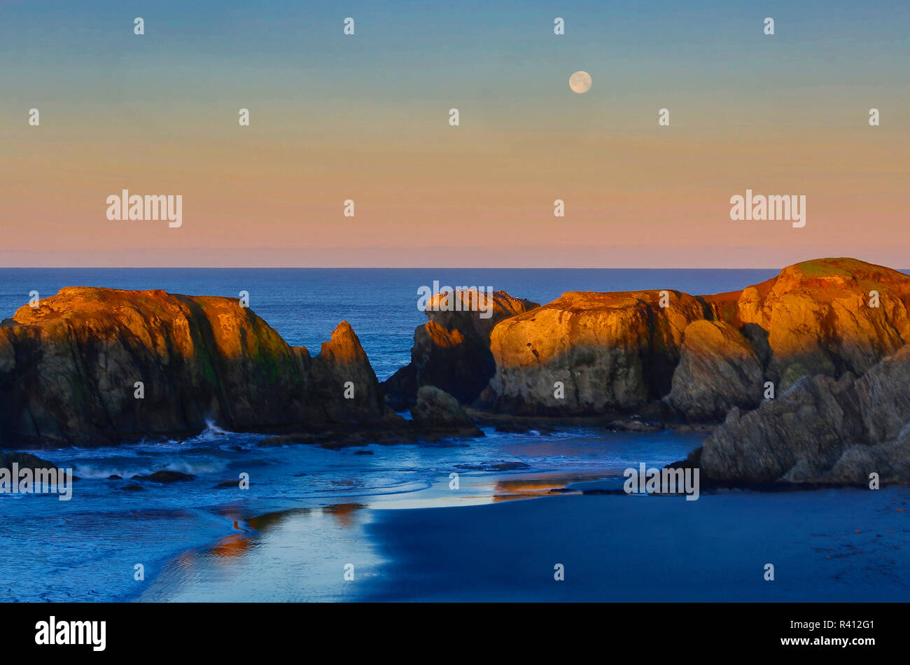 USA, Oregon, Bandon. Vollmond über Meer Stapel am Strand. Stockfoto