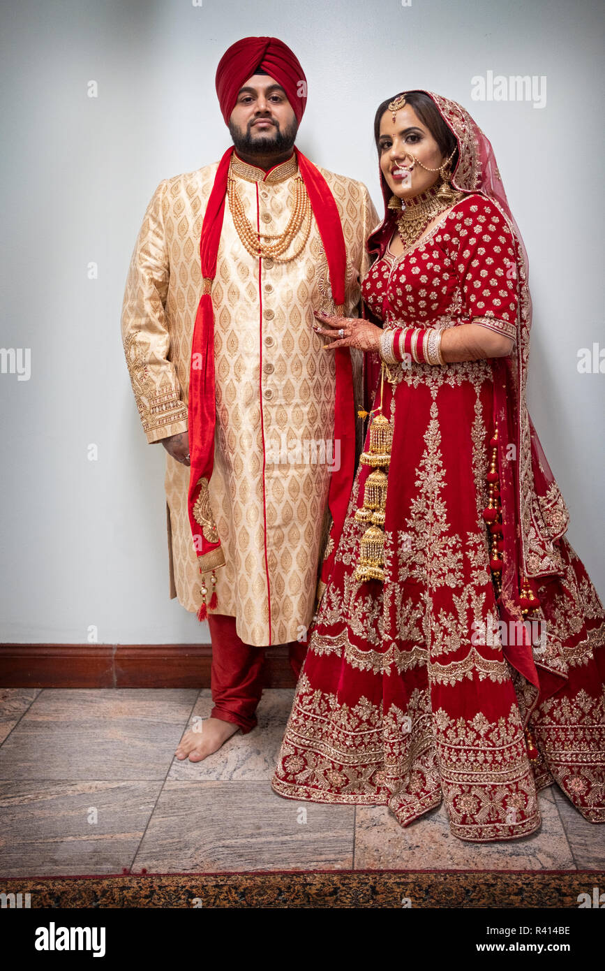 Ein Sikh Braut und Bräutigam für einen in voller Länge Porträt in einem Tempel stellen nach ihrer Trauung. Ich Queens, New York City. Stockfoto