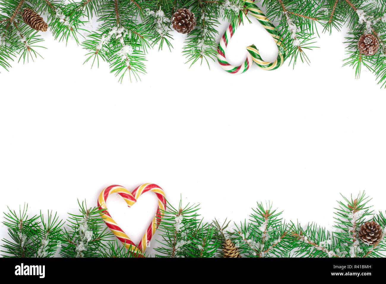 Weihnachten Rahmen der Fir Tree Branch mit Zuckerstangen und Schnee auf weißem Hintergrund mit Kopie Platz für Ihren Text isoliert Stockfoto