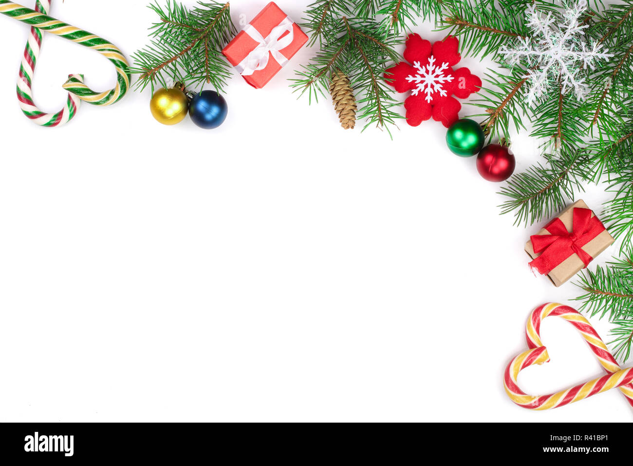 Weihnachten Rahmen der Fir Tree Branch mit Zuckerstangen und Kugeln auf weißem Hintergrund mit Kopie Platz für Ihren Text isoliert Stockfoto