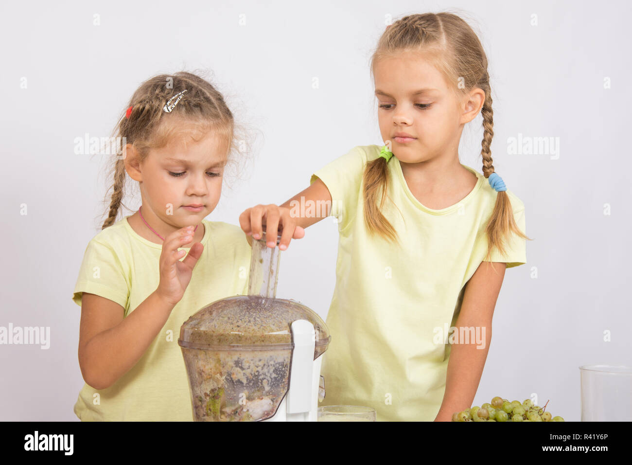 Zwei Schwestern gepresster Fruchtsaft in einem Entsafter Stockfoto