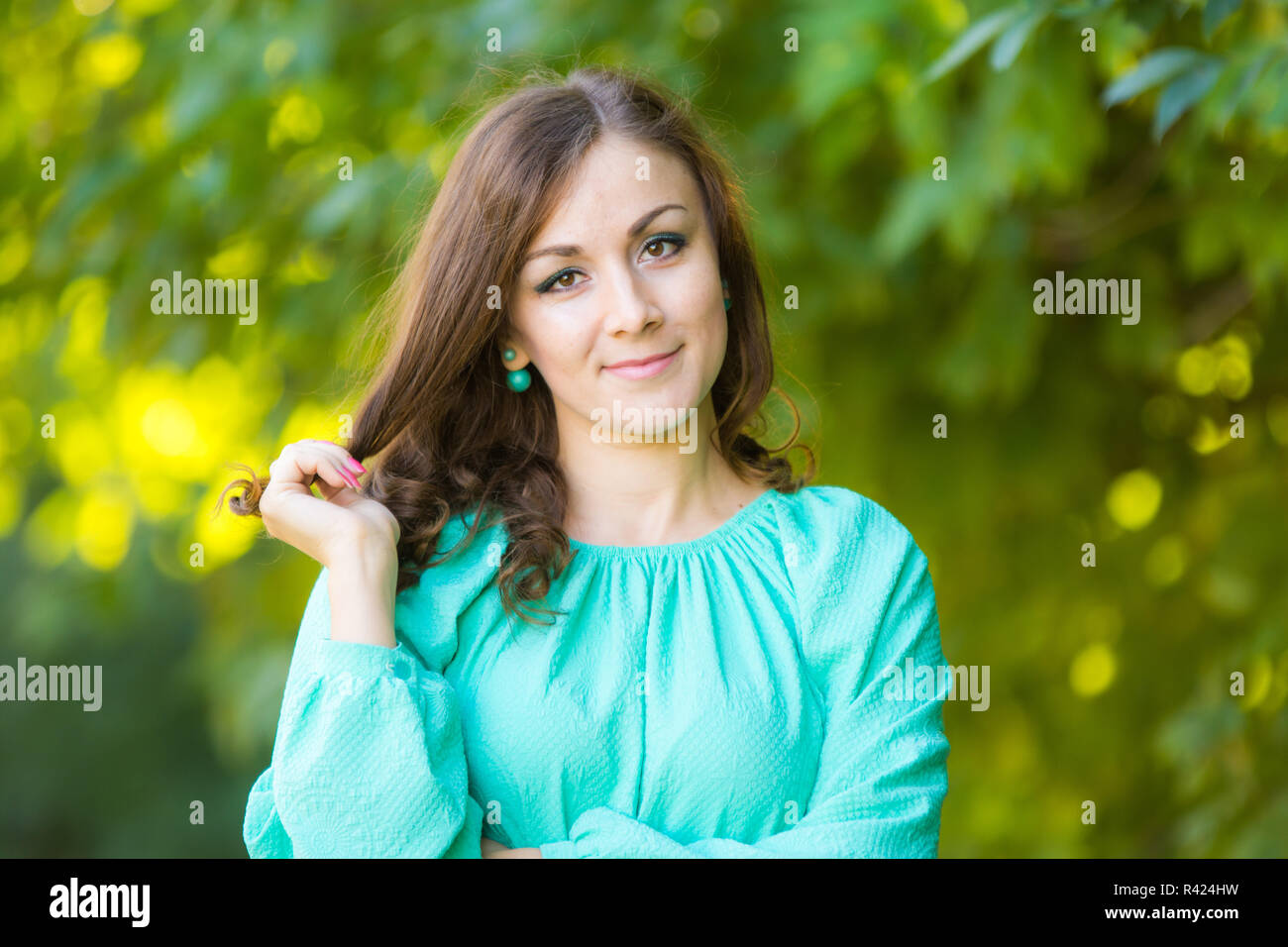 Der Taille von einem schönen Mädchen in einem Kleid auf einem Hintergrund von unscharfen grünes Laub Stockfoto