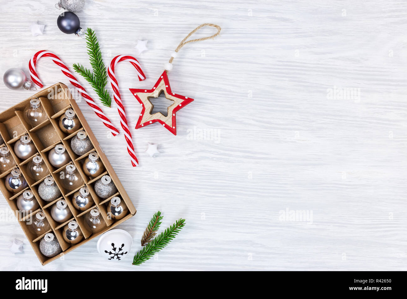 Weihnachten Dekorationen auf Holz- Hintergrund mit Fir Tree Branches, Stern, Candy Cane und Box mit Kugeln aus Glas Stockfoto