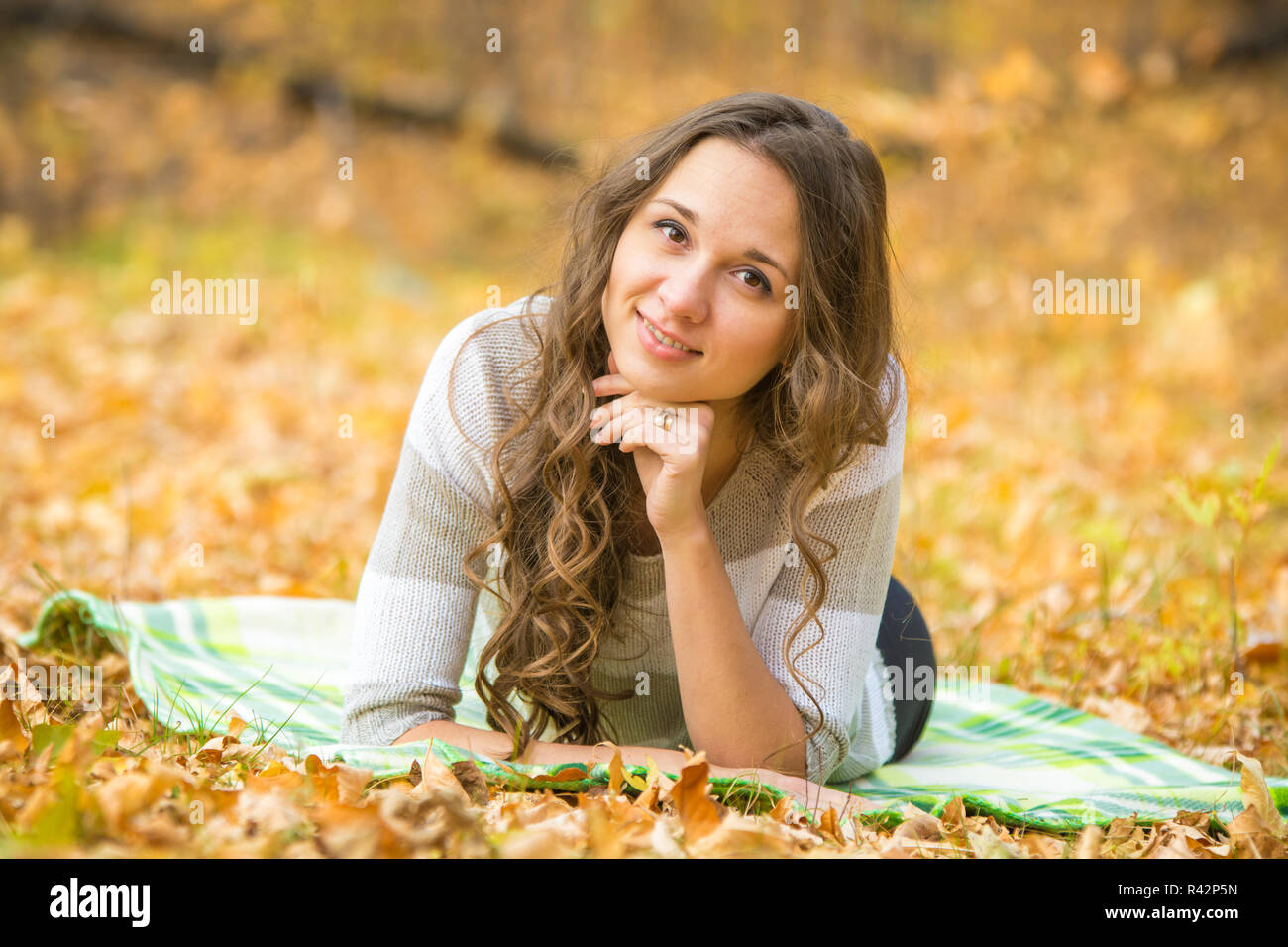 Junge schöne Mädchen auf einem Teppich in den herbstlichen Wald liegen Stockfoto