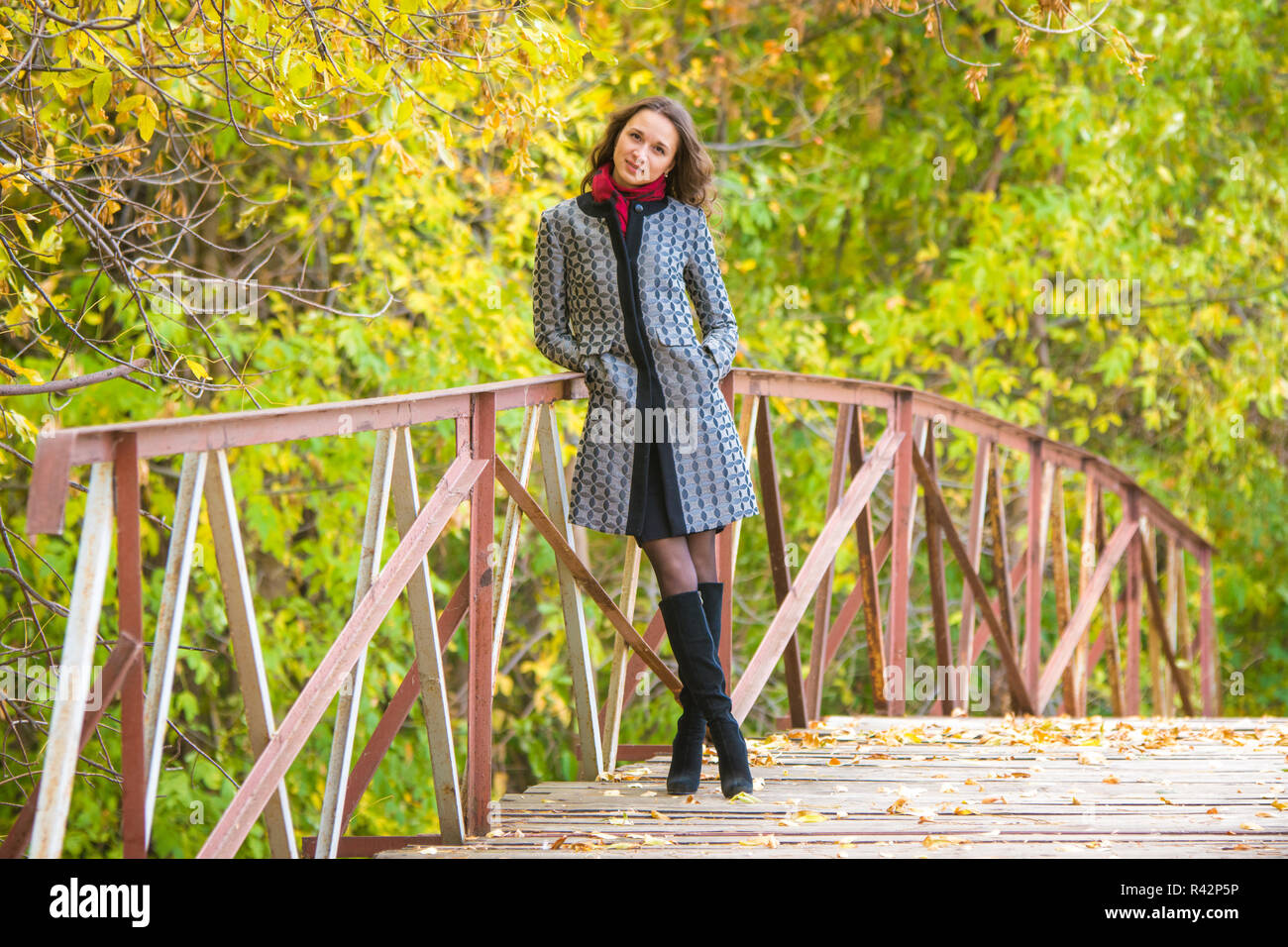 Ein junges Mädchen steht auf der Brücke von einem warmen Herbsttag Stockfoto