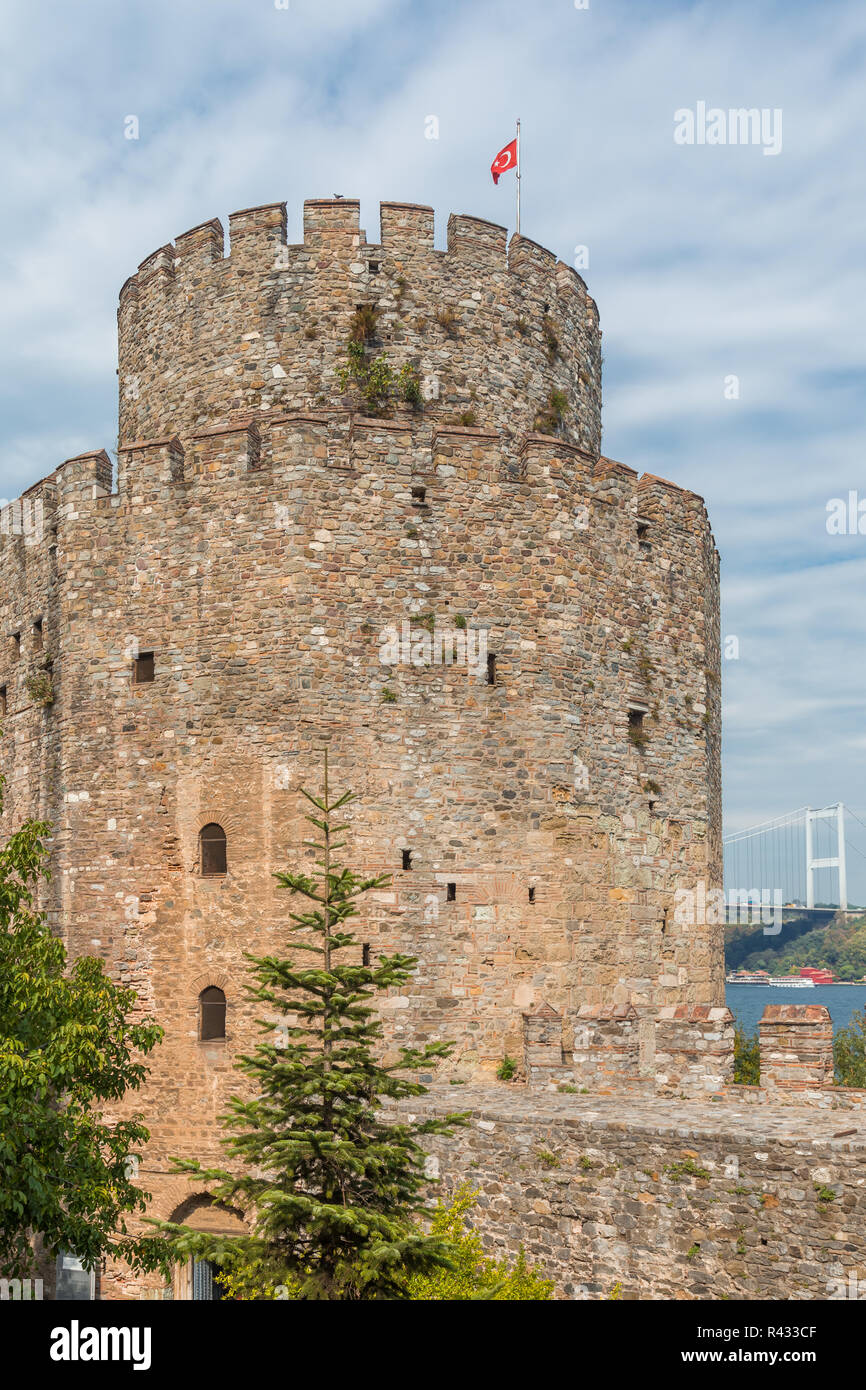Blick auf ein Wehrturm in der Festung Rumeli, Istanbul, Türkei, mit der Fatih Brücke im Hintergrund. Stockfoto
