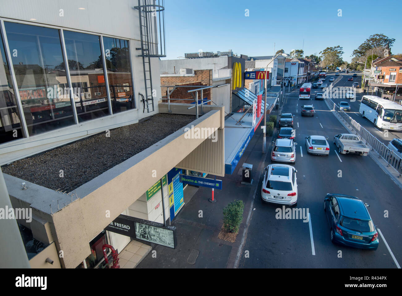 Geschäfte in unterschiedlicher Höhe und Alter der Pacific Highway an der Gordon auf North Sydney Australien Land wie Verkehr Ströme der Vergangenheit an einem Samstag Morgen. Stockfoto