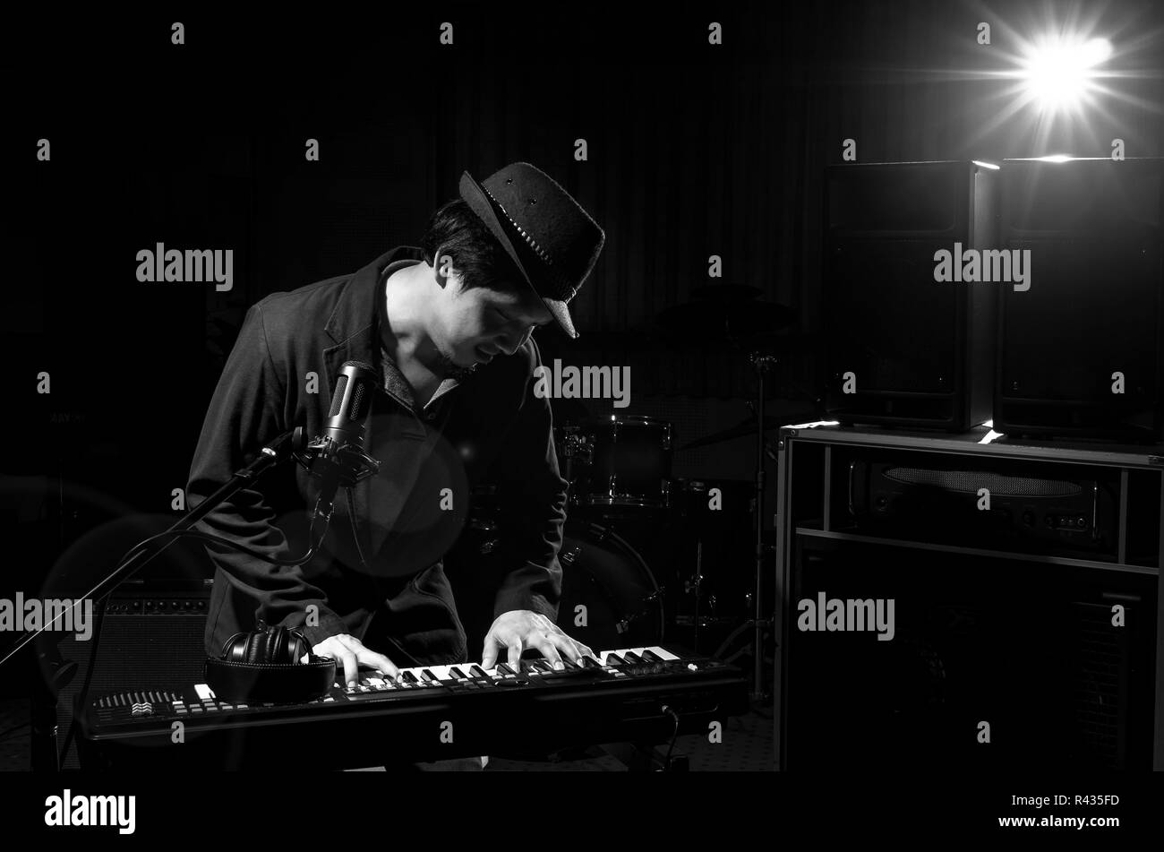 Musiker auf der Tastatur spielen mit Musik Instrument und Lens Flare von Spot Licht auf dunklem Hintergrund, Musiker Konzept Stockfoto