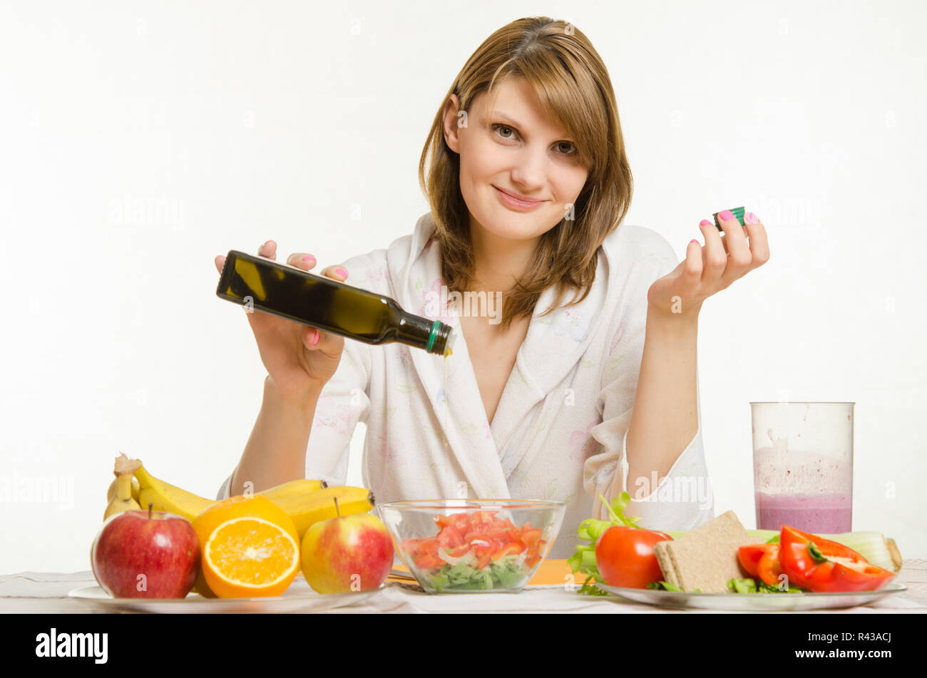Junges Mädchen gießt Öl in eine vegetarische Gemüse Vitamin Salat Stockfoto