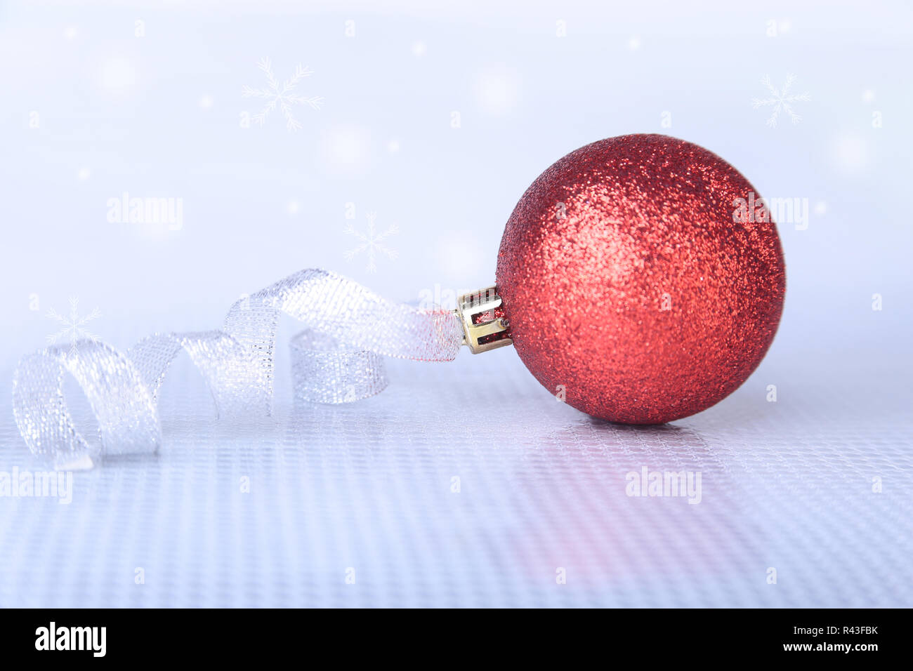 Weihnachten Hintergrund mit roten Ball und frohe Weihnachten Band auf Schnee mit Schneeflocken fallen von einem blauen Himmel Stockfoto