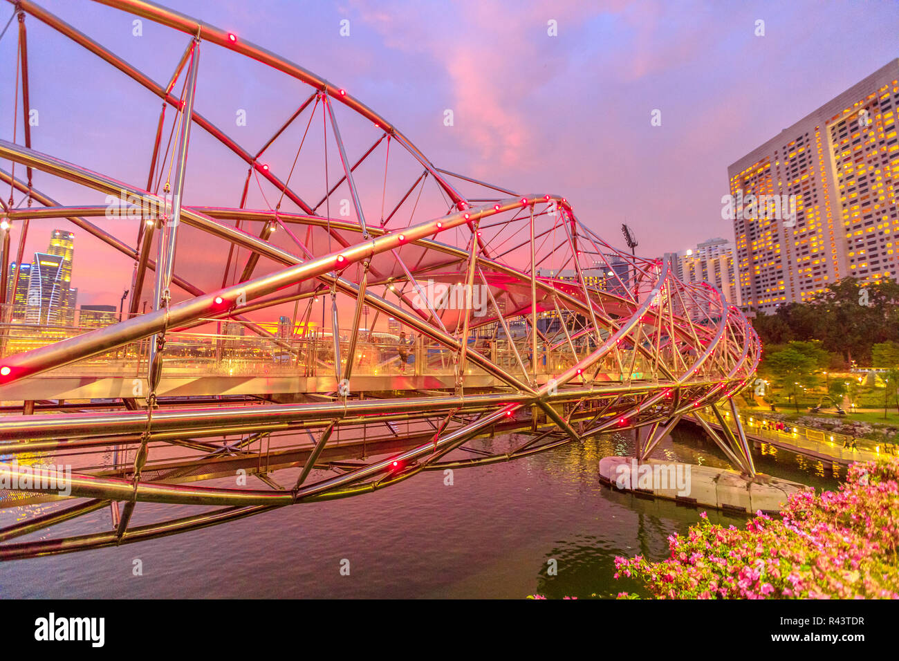 Moderne Fußgängerbrücke an der blauen Stunde in der Marina Bay, Singapore City. Berühmte Ort für Reiseziel. Malerische Stadtbild in der Dämmerung. Stockfoto