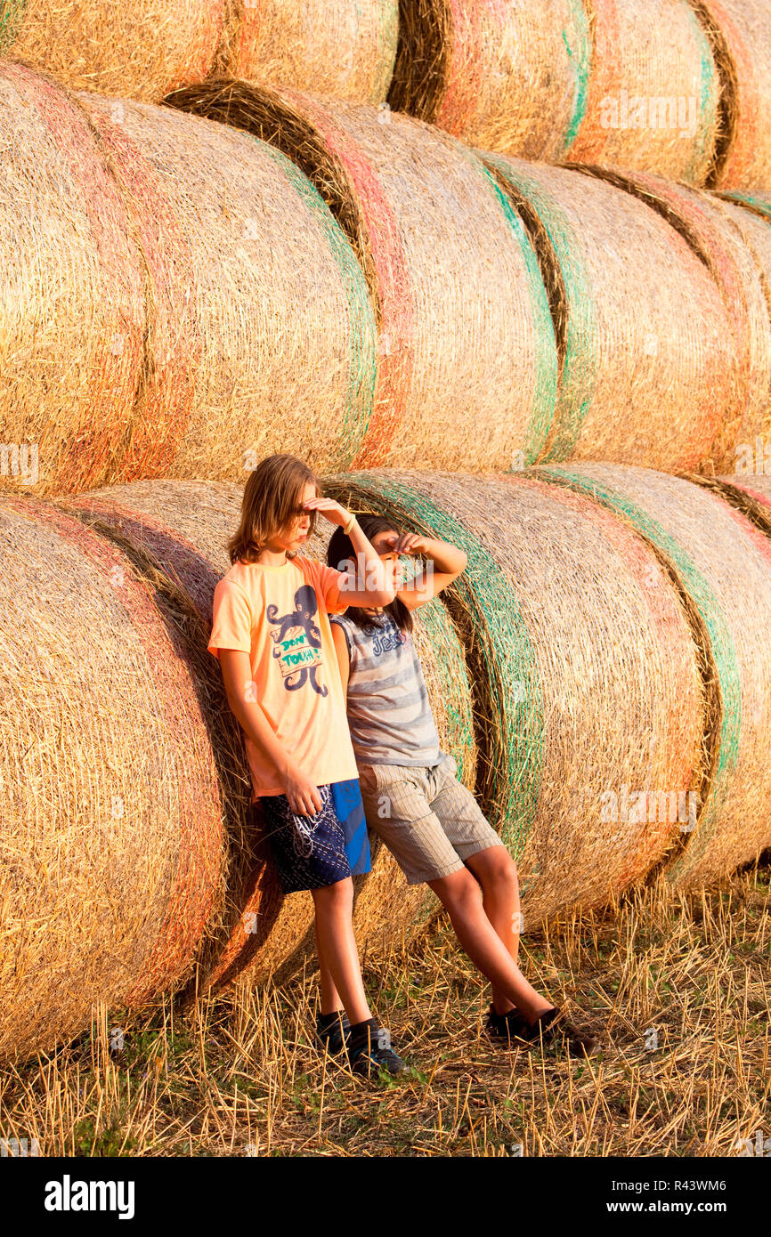 Zwei Jungen Spaß mit Heuballen im Sommer. Stockfoto