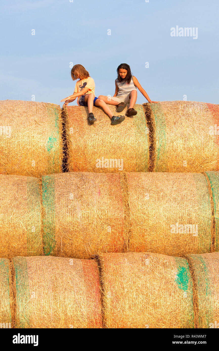 Zwei Jungen Spaß mit Heuballen im Sommer. Stockfoto