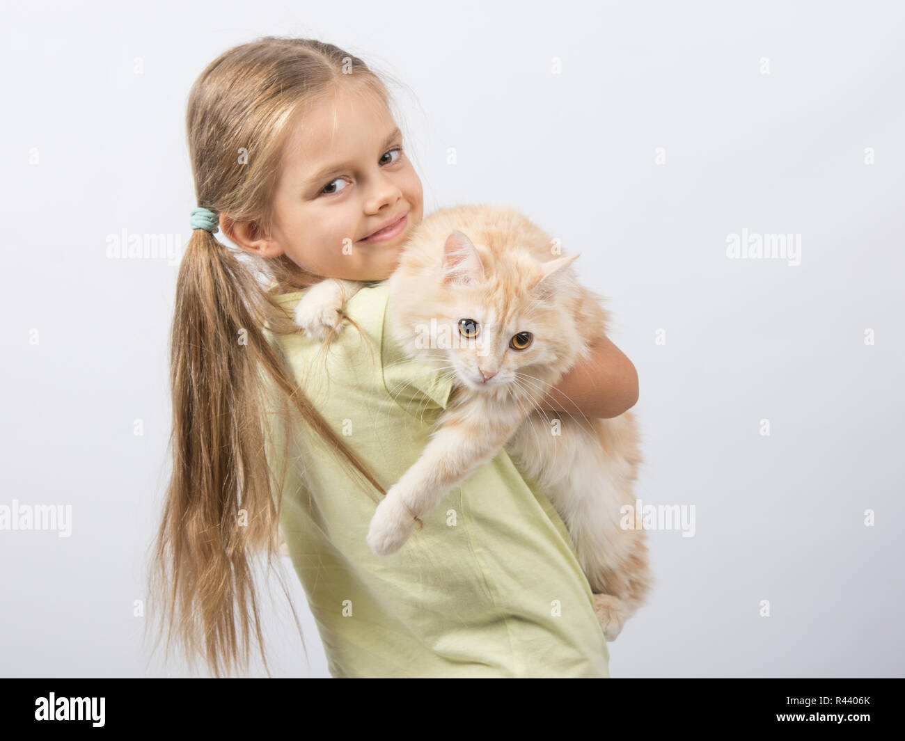 Sechs Jahre altes Mädchen hält eine Katze im Arm Stockfoto