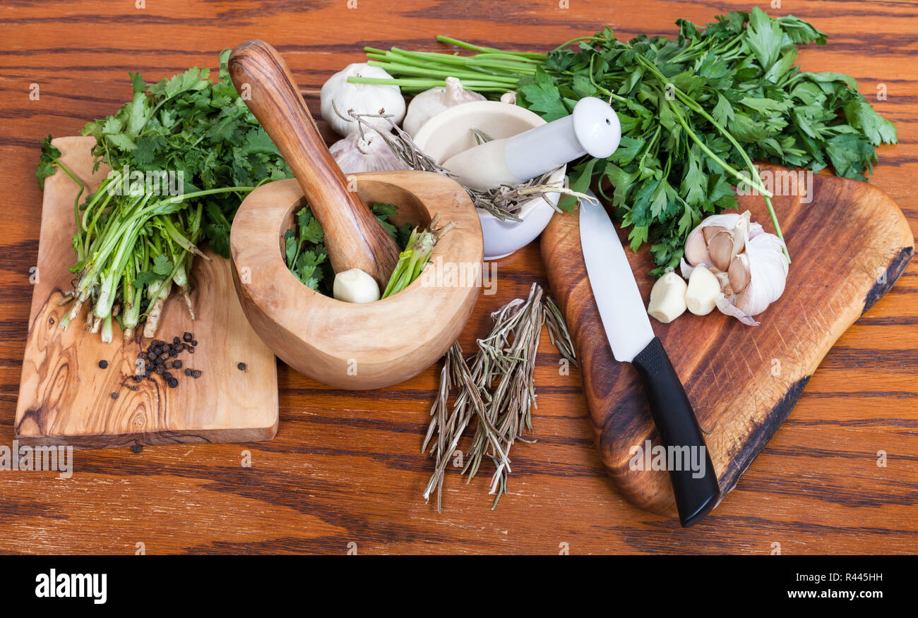 Mörtel und würzige Zutaten auf hölzernen Tisch Stockfoto