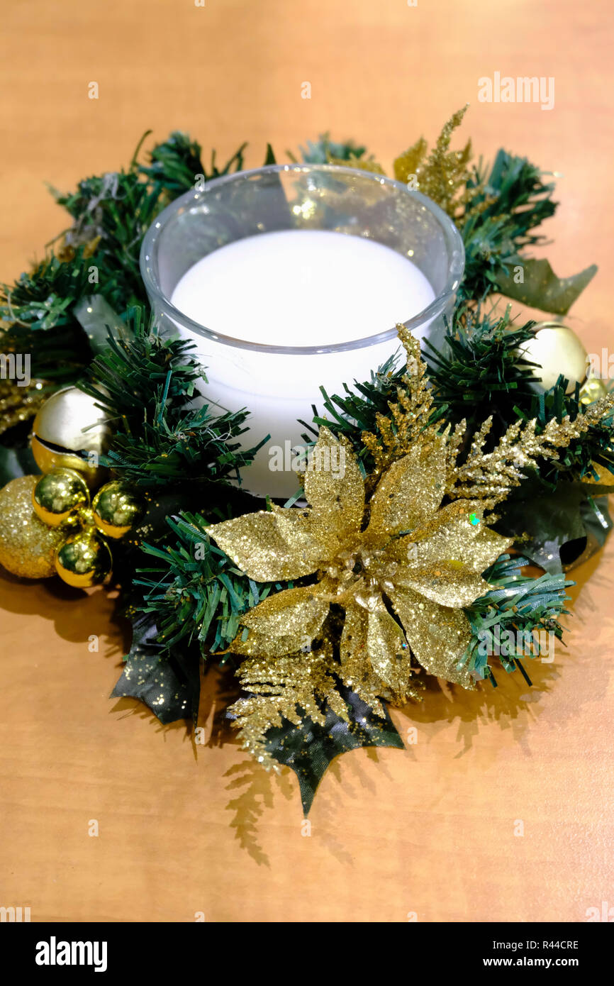 Weihnachten Tischdekoration. Weiße Kerze im Glas durch Gold Flitter und glitter Blumen umgeben. Stockfoto