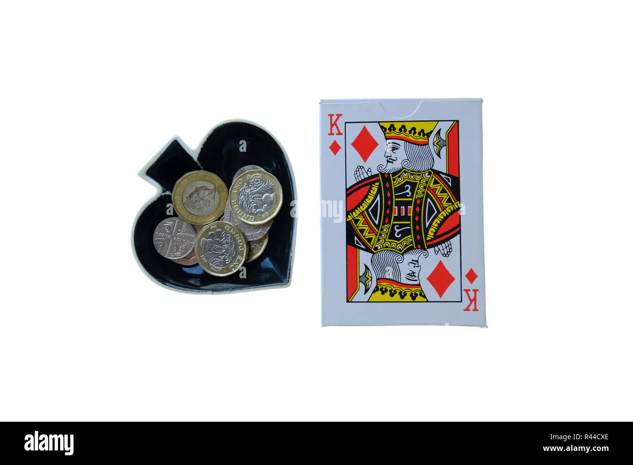 Packung mit traditionellen Spielkarten auf weißem Hintergrund mit Ace of Spades geformte Schmuckstück Schüssel auf die Seite mit Loose Change. Stockfoto