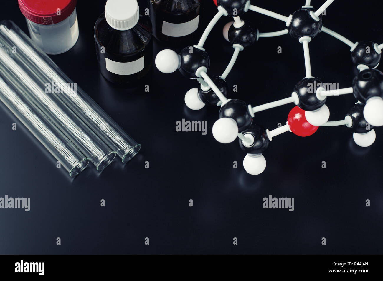 Molekülformel und Laborgeräte auf dunklem Hintergrund. Wissenschaft organische Chemie Konzept Stockfoto