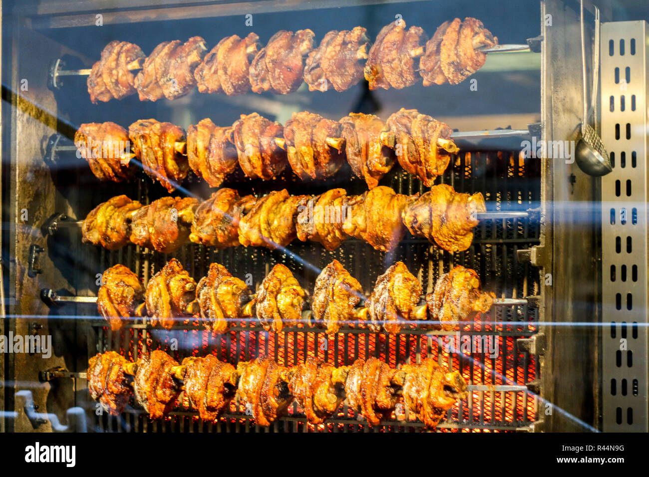 Gebratene Hühner, Hähnchen vom großen Spieß braten, restaurant Fenster München Deutschland, Abendessen Konzept, Fleisch essen Konzept, vegan, köstliche, Stockfoto