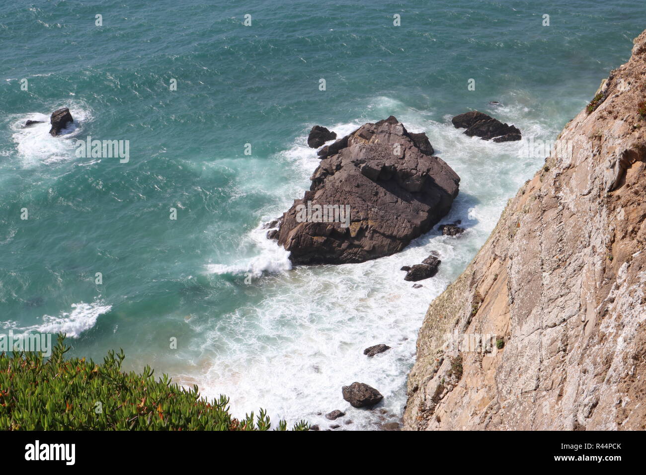 Wellen gegen einen Felsen - Cabo da Roca, Colares, Portugal. Stockfoto