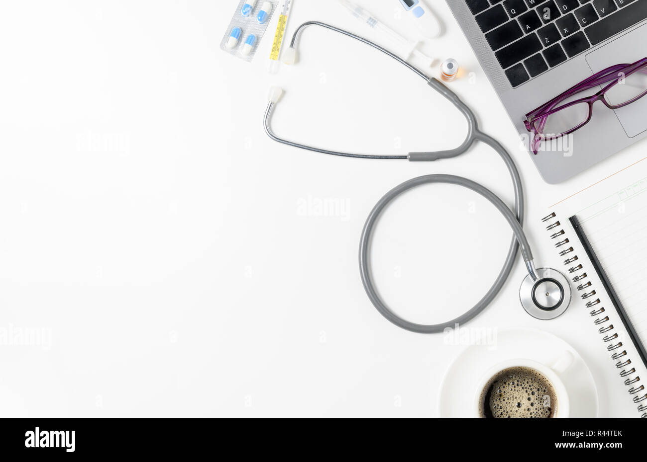 Draufsicht des Doktors Schreibtisch Tisch mit Stethoskop, Kaffee und Laptop. Ansicht von oben mit der Kopie Raum, flach. Stockfoto
