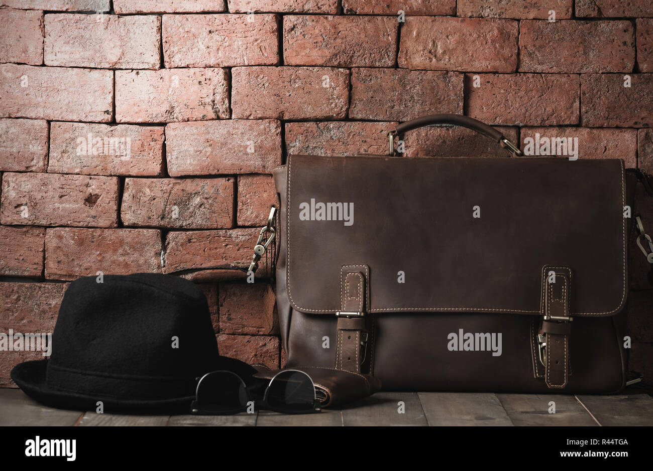 Vintage Leder Tasche mit Sonnenbrille und Hut auf Holz Tisch, Accessoires hipster Style, für Reisen Konzept und vintage Ton vorbereiten Stockfoto