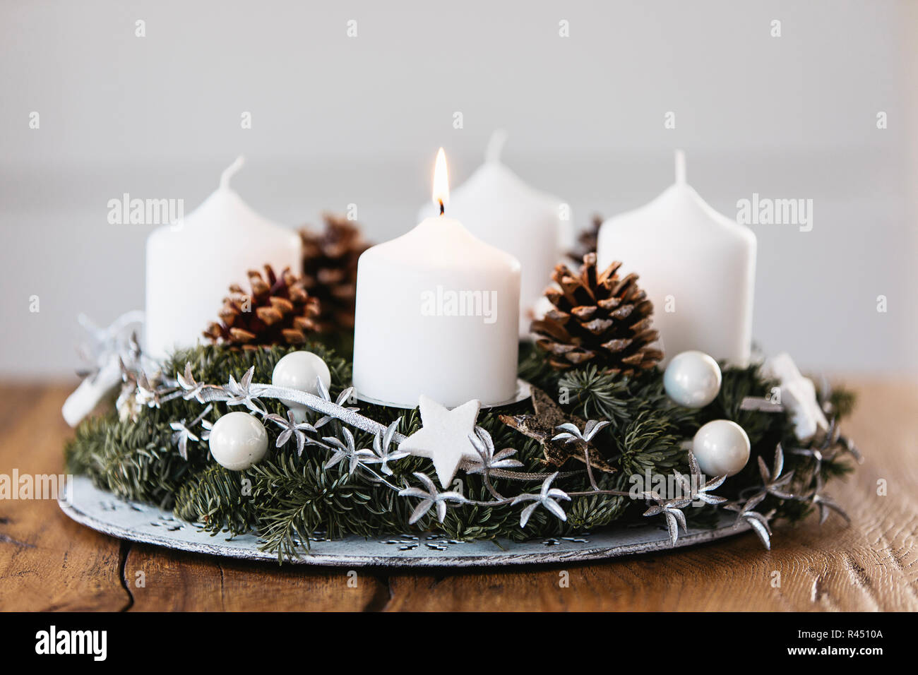 Beleuchtung Die erste Kerze am Adventkranz am ersten Sonntag im Dezember  Der beginiing von Weihnachten in der Schweiz zu feiern Stockfotografie -  Alamy