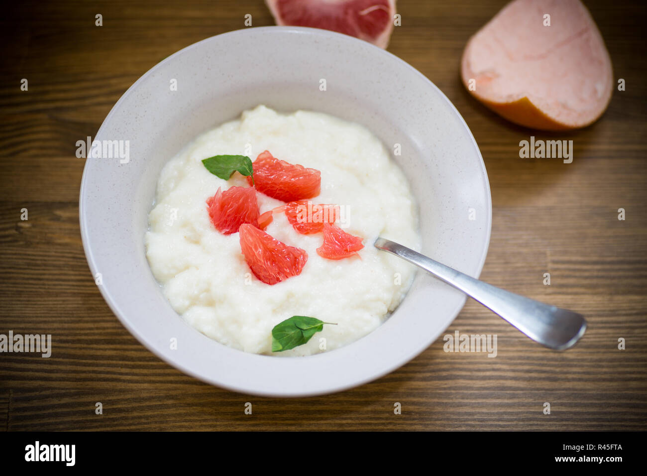 Süße gekochte Grieß Brei in eine Platte mit Scheiben Rote Grapefruit Stockfoto