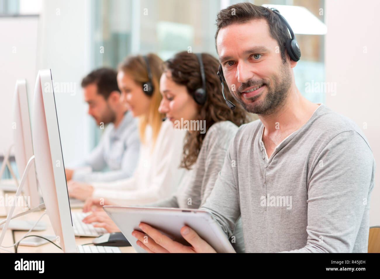 Jungen attraktiven Mann bei der Arbeit in einem Call Center Stockfoto