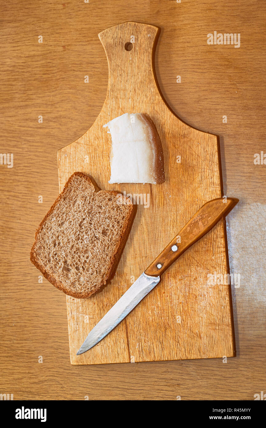 Schmalz, Messer und Roggenbrot auf Schneidebrett Stockfoto