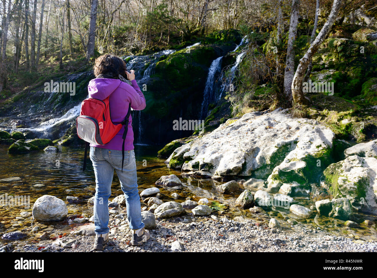 Frau Fotograf fotografieren einen Wasserfall, im Herbst Stockfoto