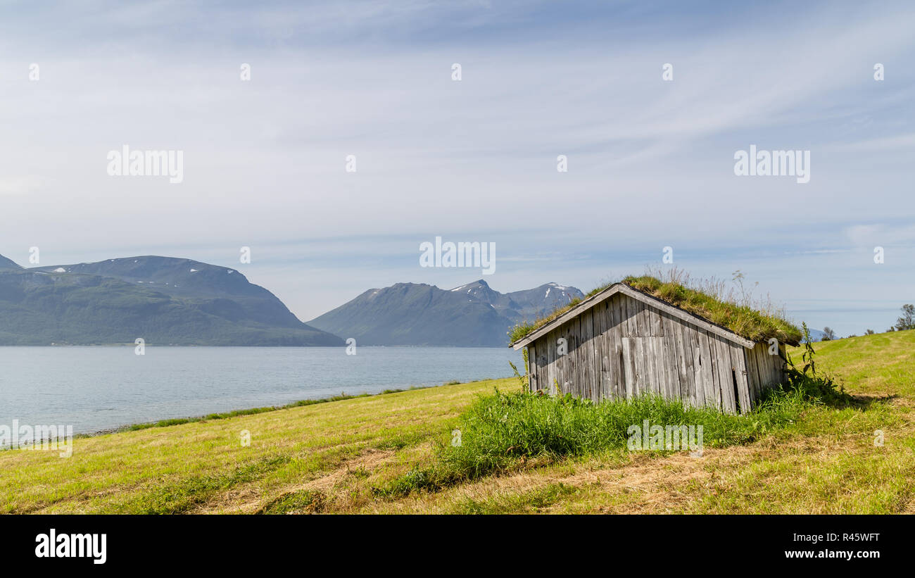 Typische Skandinavische Landschaft Mit Einer Alten Hutte Mit Einem Grunen Dach An Einem See Stockfotografie Alamy