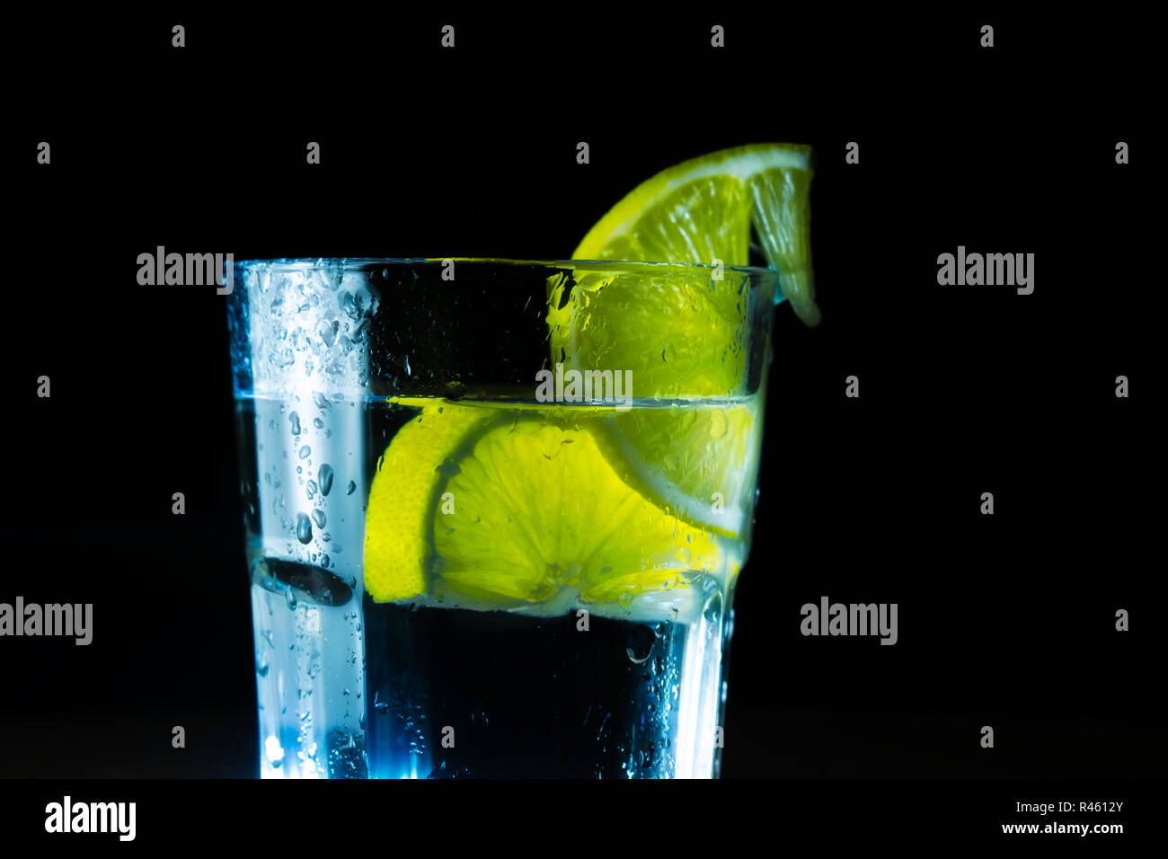 Glas Wasser und Zitrone auf schwarzem Hintergrund Stockfoto