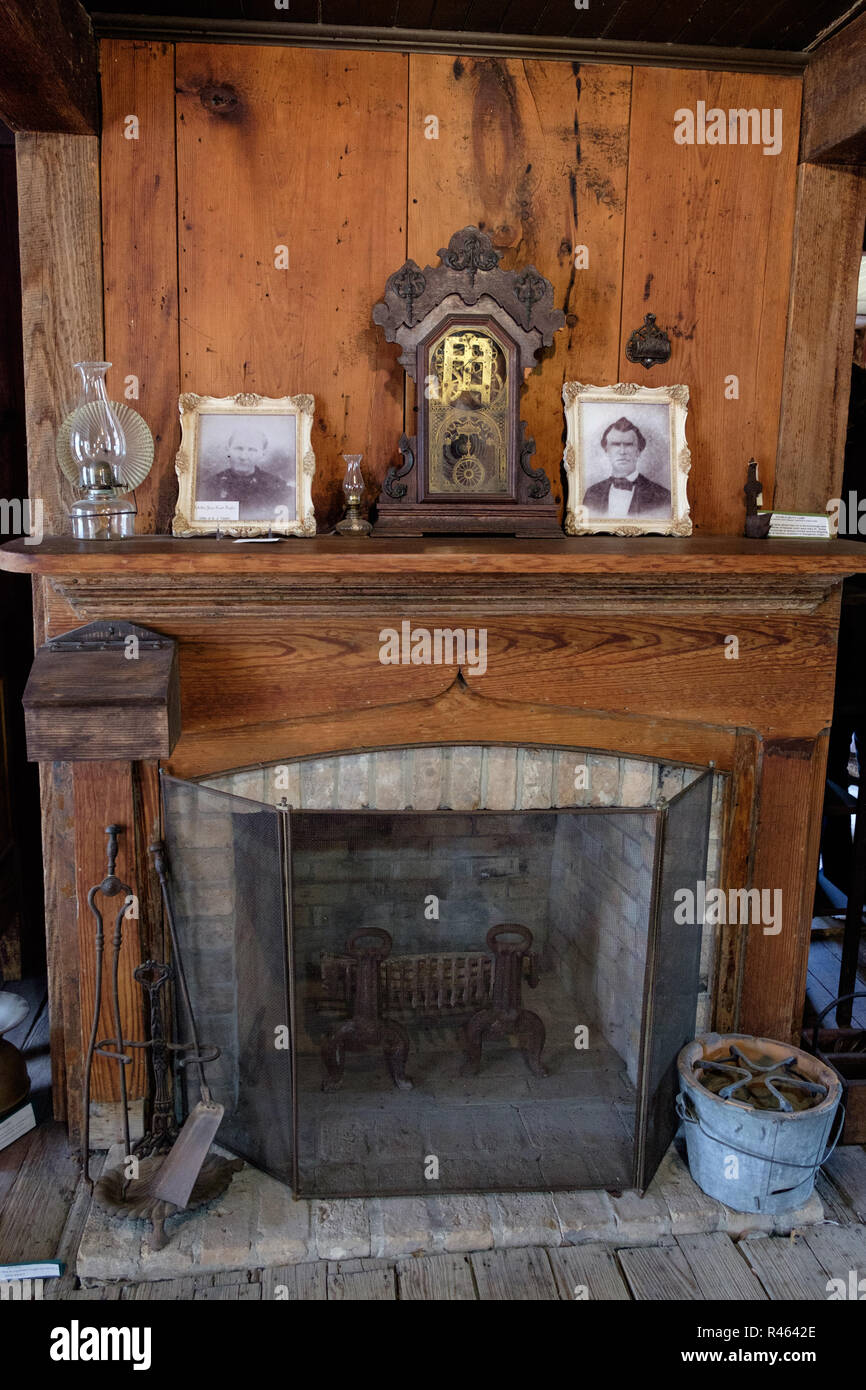 Vintage Texan Home Interieur mit antikem Kamin, Uhr, Fotos in Frames & Öllampen. Chestnut Square Historic Village, McKinney, Texas. Stockfoto