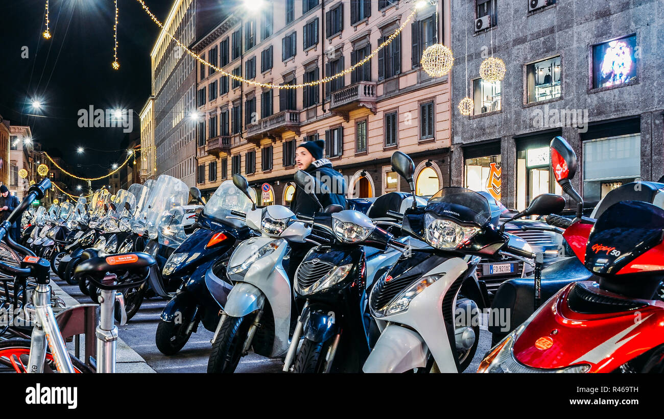 Reihen von geparkten Motorroller in Mailand bei Nacht. Vespas sind eine Ikone der italienischen Art des Transports gemeinsame in Italien Stockfoto